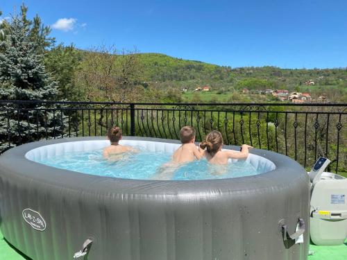 a group of three people in a hot tub at Children Cottage Župkov - in gorgeous valley in Župkov