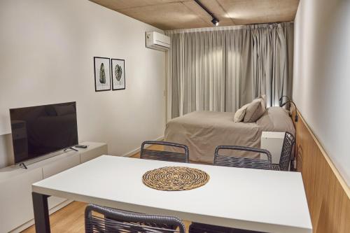 a small room with a bed and a table and chairs at Babel Arcos in Buenos Aires