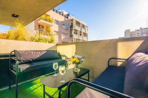 una mesa y sillas en un balcón con copas de vino en Deluxe Apartments in Palermo en Buenos Aires