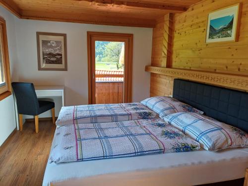 - une chambre avec un lit, un bureau et une fenêtre dans l'établissement Landhaus Eberler, à Mayrhofen