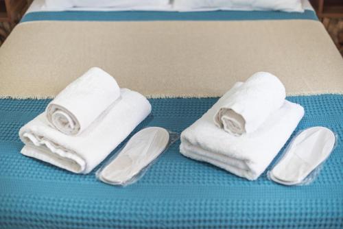 two towels and a pair of slippers on a bed at CONTEMPORARY APARTMENT 200M FROM ACROPOLIS 100Mbps NETFLIX in Athens