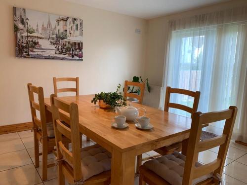a dining room table with chairs and a wooden table at Elm Park Escape - 4 bed self-catering holiday home in Buncrana