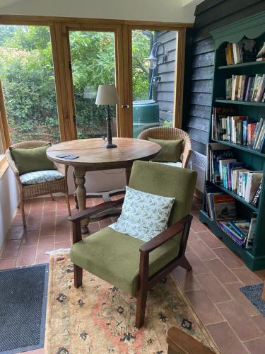 Habitación con mesa, sillas y estante para libros. en Mulleys Cottage (Bed and Breakfast), en Westleton