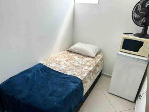 a small bedroom with a bed and a microwave at Studio em Santana ao lado expor center norte in São Paulo