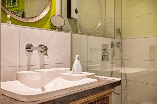 a bathroom with a sink and a shower at Deichkind Viertel Suite in Bremen