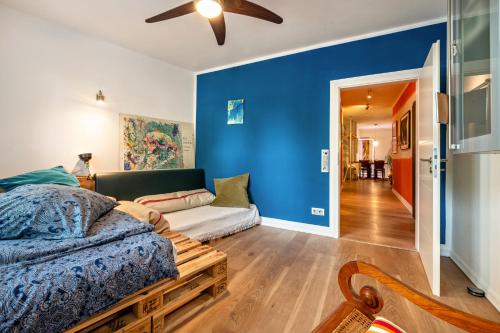 a bedroom with blue walls and a bed and a couch at Deichkind Viertel Suite in Bremen