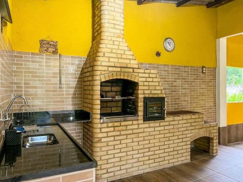 アングラ・ドス・レイスにあるCasa com churrasqueira e piscina, perto de riachoの時計付きレンガ製オーブン