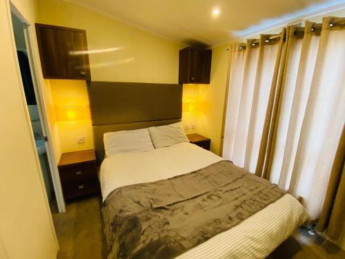 um pequeno quarto com uma cama e uma janela em ABRIDGE PANORAMIC House em Theydon Bois