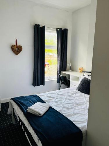 a bedroom with a bed and a window at Coventry City House - Room 3 in Coventry