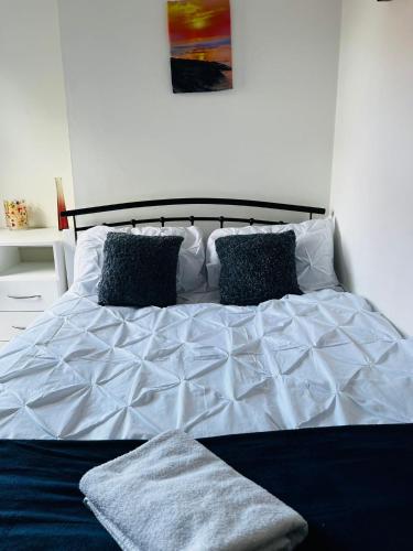 a bed with a white comforter and two pillows at Coventry City House - Room 3 in Coventry