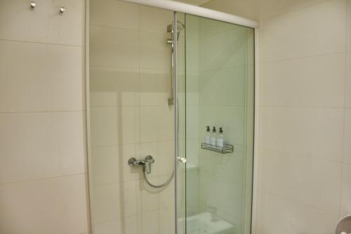 a bathroom with a shower with a glass door at Babel Arcos in Buenos Aires