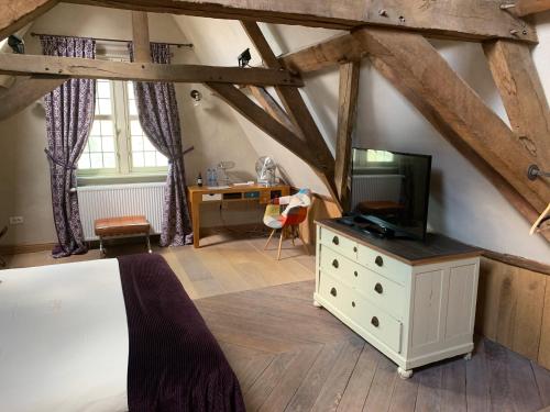 - une chambre avec un lit et une télévision sur une commode dans l'établissement B&B Saint-Sauveur Bruges, à Bruges