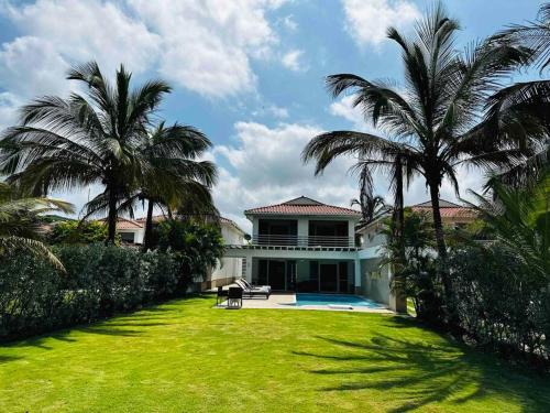 una casa con un gran patio con palmeras en ¡Fantastic Beach House!, en Arroyo de Piedra