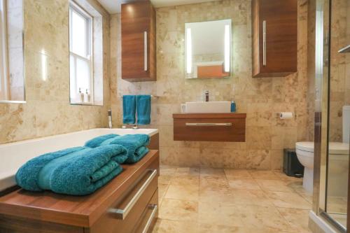 a bathroom with a tub and a sink and a toilet at The London Nest: 2BR City Haven in London