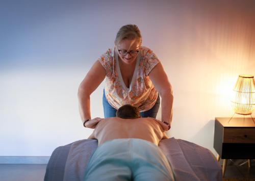 a woman standing next to a man laying on a bed at Le Gîte Cookie in Urschenheim