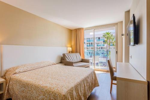 a hotel room with a bed and a chair and a window at Hotel Best Maritim in Cambrils