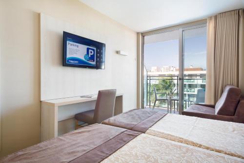 a hotel room with a bed and a desk and a window at Hotel Best Maritim in Cambrils