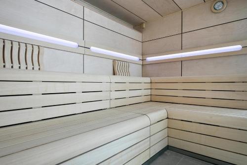 a sauna with wooden benches and a clock in it at Hotel Best Maritim in Cambrils