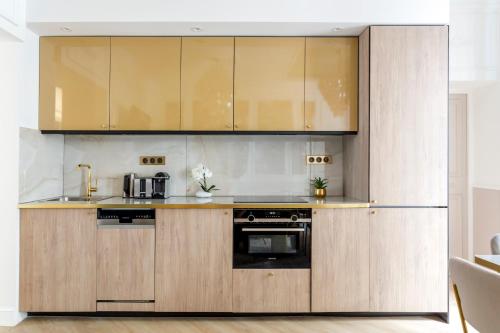a kitchen with wooden cabinets and a stove at Luxury 6 Bedroom 3 Bathroom Louvre Champs Elysees in Paris