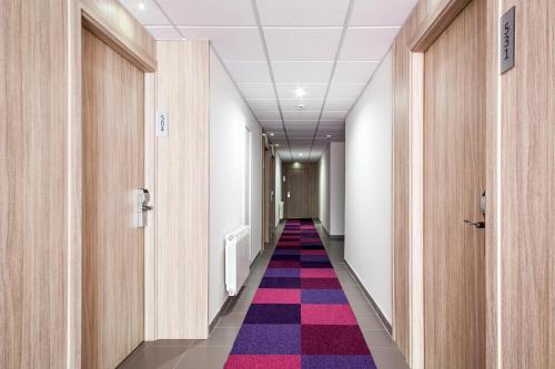 a corridor of an office building with a colorful carpet at Hotel Best San Francisco in Salou