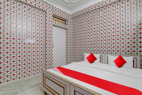 sypialnia z łóżkiem z czerwonymi poduszkami w obiekcie Flagship Shri Ram Hotel w mieście Chinhat