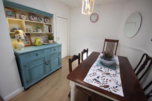 a dining room with a table and a blue cabinet at Moy Fishermans retreat Foxford in Foxford