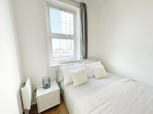 a white bedroom with a bed and a window at 1 Bedroom City Gem, Prime Location. in Woolwich