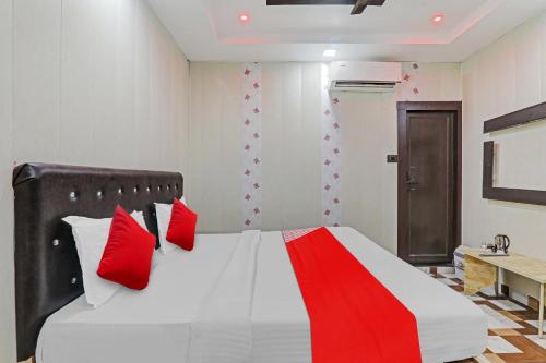 a bedroom with a large bed with red pillows at OYO Flagship Ganga Galaxy Hotels And Banquet in Kānpur