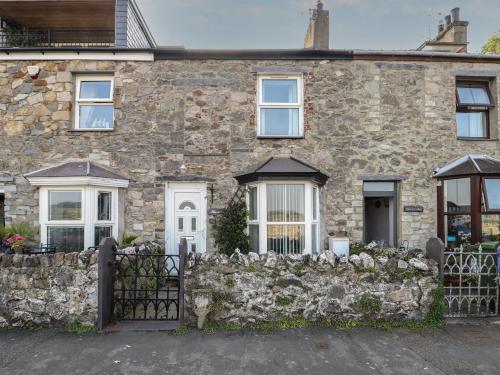 una casa de piedra con una valla de piedra en 23 Beach Road, en Y Felinheli