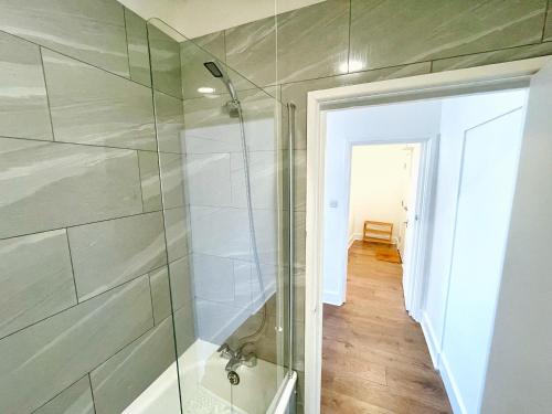 a bathroom with a shower with a glass door at 1 Bedroom City Gem, Prime Location. in Woolwich