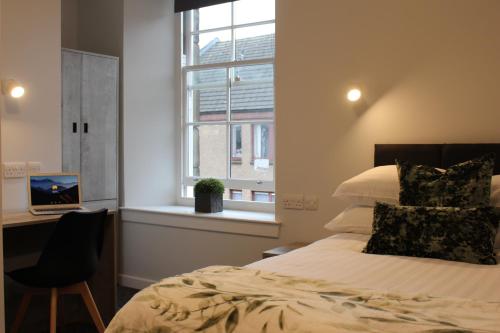 sypialnia z łóżkiem, biurkiem i oknem w obiekcie The Arches - The Big Yin w mieście Stirling