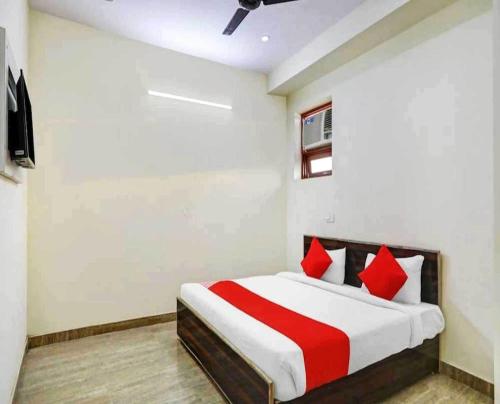 a bedroom with a large bed with red pillows at Hotel Sky Bird in Bhauli