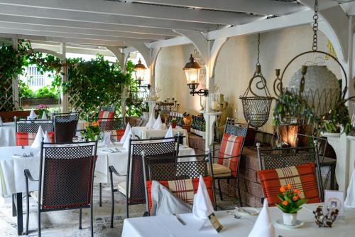 Hotel Alt Vellern في بيكم: مطعم بطاولات بيضاء وكراسي ونباتات