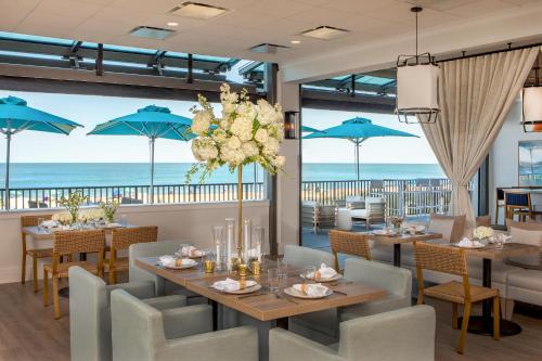 a dining room with tables and chairs and the ocean at Ashore Resort & Beach Club in Ocean City