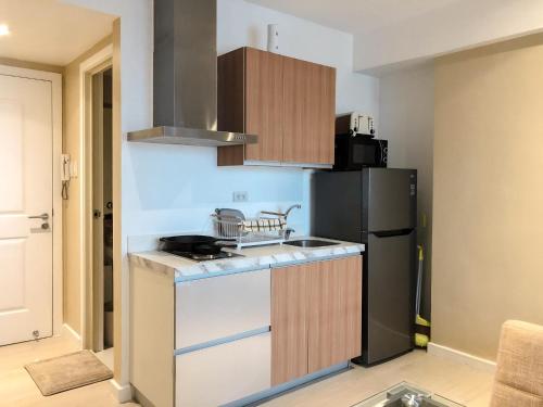 a kitchen with a stove and a refrigerator at The Crash Pad in Manila