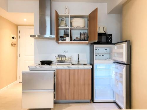 a kitchen with a refrigerator and a stove top oven at The Crash Pad in Manila