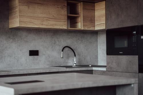 uma cozinha com um lavatório e um micro-ondas em Fitromax Apartmanház em Ajka