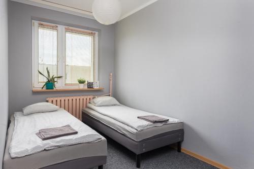 2 łóżka pojedyncze w pokoju z oknem w obiekcie Pokoje Wasilkowskiego w Warszawie
