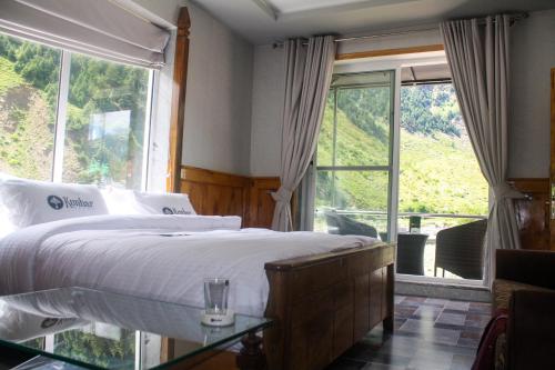 a bedroom with a bed and a large window at Kunhar Hotel RiverSide Block in Naran