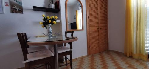 Cette chambre dispose d'une table avec un vase de fleurs. dans l'établissement Apartmani Nata, à Maslinica