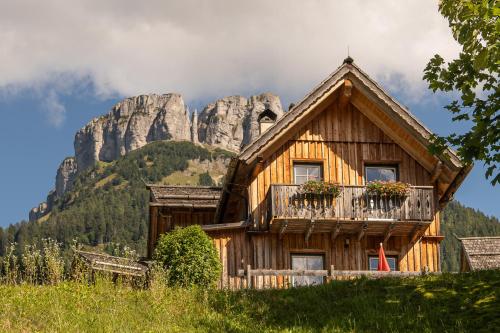 a wooden house with a mountain in the background at AlpenParks Hagan Lodge Altaussee in Altaussee