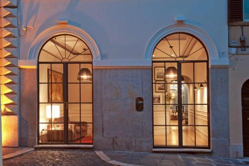 two arched windows on the side of a building at The Fifteen Keys Hotel in Rome