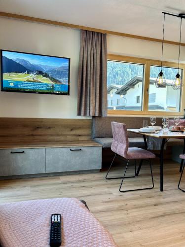 a living room with a tv on the wall at Apart Eder in Schwendau