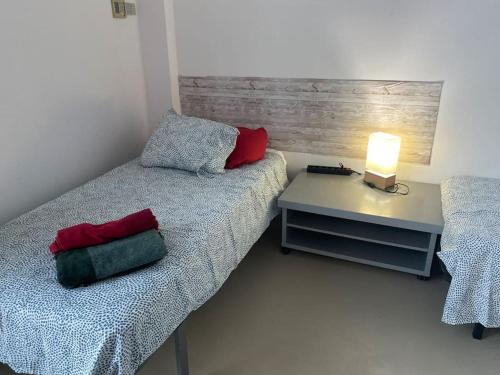 - une chambre avec un lit et une table avec une lampe dans l'établissement “El SEIS”, à Madrid