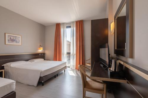 a hotel room with two beds and a flat screen tv at Hotel Ristorante Al Mulino in Alessandria