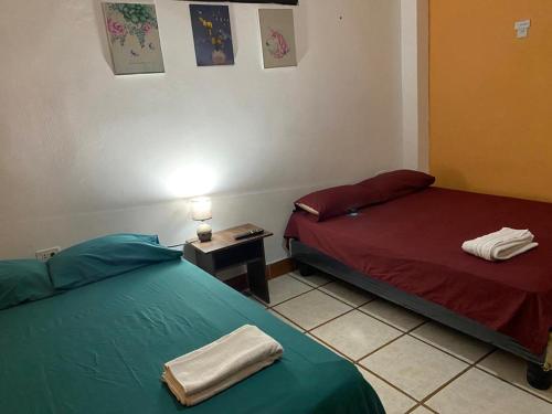 a room with two beds and a table with a lamp at Departamentos en la Garzota cerca del Aeropuerto Norte de Guayaquil in Guayaquil
