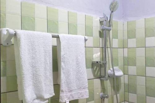 a bathroom with white towels hanging from a shower at Ouidah Lodge in Ouidah