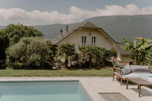 a house with a swimming pool in front of a house at Chez Anne et Grégoire in Voglans