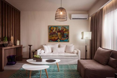 a living room with a couch and a table at Ermioni Luxury Suite Beachfront 1 minute from the beach in Stalida