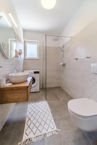 a bathroom with a sink and a toilet and a mirror at Janie in Splitska